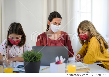 Group of homeschooling children with teacher studying indoors, coronavirus concept. Group of homeschooling children with teacher studying indoors, coronavirus concept. 70620155