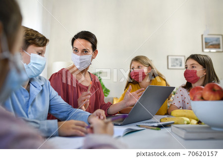 Group of homeschooling children with teacher studying indoors, coronavirus concept. Group of homeschooling children with teacher studying indoors, coronavirus concept. 70620157