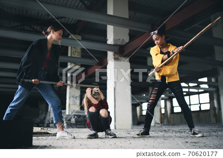 Teenage girl attacked by thugs in abandoned building, gang violence and bullying concept. 70620177