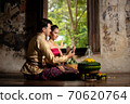 Thai couple in traditional dress costume making and decorating Krathong. Loy Krathong Festival. 70620764