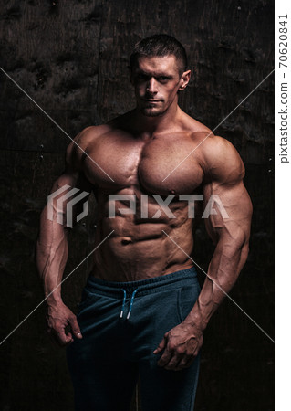 Sporty and healthy muscular man on dark grunge background Sporty and healthy muscular man on dark grunge background 70620841
