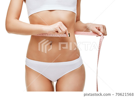 Slim tanned woman's body isolated on white background - waist measurement 70621568