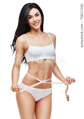 Slim tanned woman's body isolated on white background - waist measurement 70621580