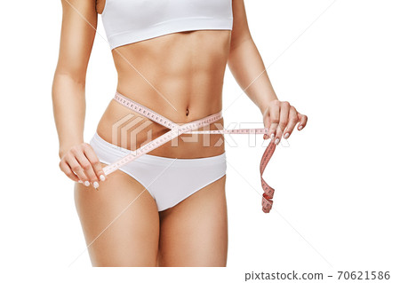 Slim tanned woman's body isolated on white background - waist measurement 70621586