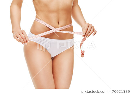 Slim tanned woman's body isolated on white background - waist measurement 70621589