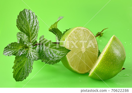 Lime with leaf mint on a green background. 70622286