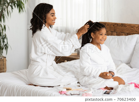 Home Beauty Salon. Loving Black Mom Braiding Hair To Her Little Daughter Home Beauty Salon. Loving Black Mom Braiding Hair To Her Little Daughter 70623400