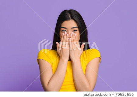 Happy Excitement. Cheerful Brunette Woman Sincerely Smiling And Covering Mouth With Hands, Received Pleasant Surprize, Having Positive Emotions, Standing Over Purple Studio Background, Copy Space Happy Excitement. Cheerful Brunette Woman Sincerely Smiling And Covering Mouth With Hands, Received Pleasant Surprize, Having Positive Emotions, Standing Over Purple Studio Background, Copy Space 70623696