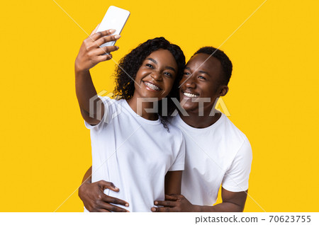 Happy african american couple taking selfie on smartphone 70623755