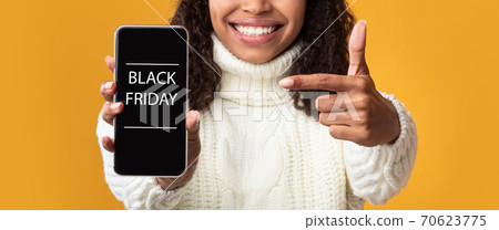 Woman showing cell phone with black friday text on screen Woman showing cell phone with black friday text on screen 70623775