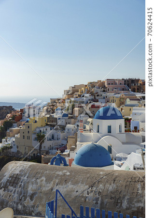 Greece Santorini Oia A church with a blue roof on a longing white wall Greece Santorini Oia A church with a blue roof on a longing white wall 70624415