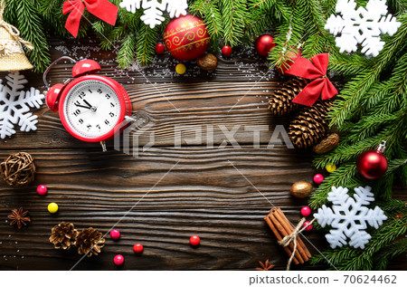 Christmas background of spruce branches with pine cones berries and alarm clock on wooden table with copy-space Christmas background of spruce branches with pine cones berries and alarm clock on wooden table with copy-space 70624462