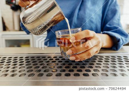 Close up of female barista making a flat white coffee Close up of female barista making a flat white coffee 70624494