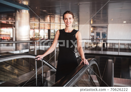 Elegant woman using an escalator in the airport 70626222