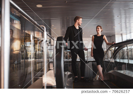 Man and woman using the escalator in the airport Man and woman using the escalator in the airport 70626257