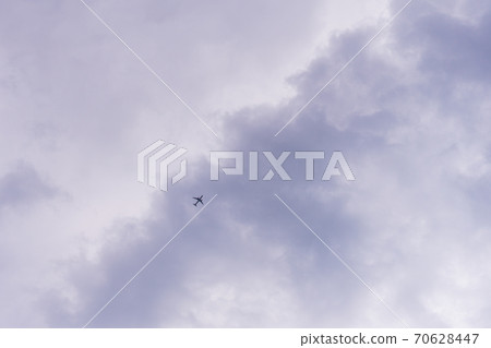 Plane flying against a sky full of clouds Plane flying against a sky full of clouds 70628447
