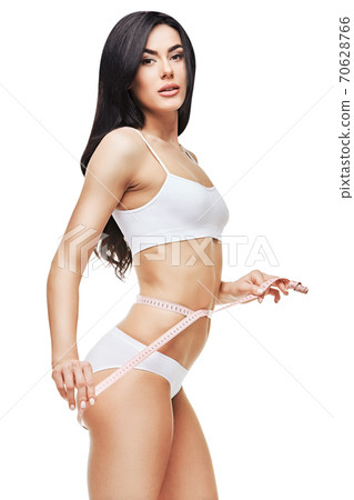 Slim tanned woman's body isolated on white background - waist measurement 70628766