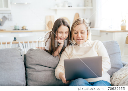 mom and daughter on the couch with a laptop mom and daughter on the couch with a laptop 70629655