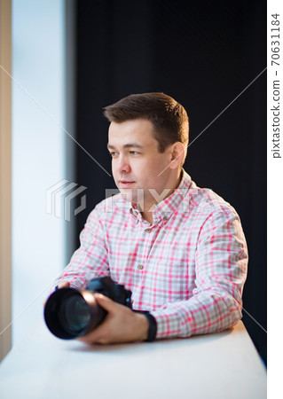 photographer holds a camera. creative profession. photographer holds a camera. creative profession. 70631184