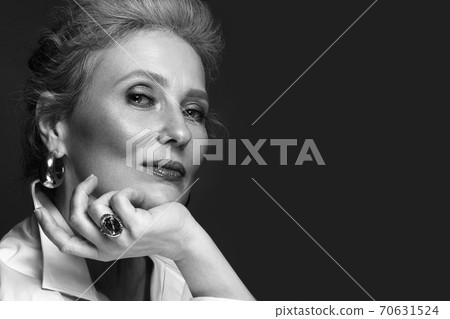 Portrait of a beautiful elderly woman in a white shirt with classic makeup and gray hair. Portrait of a beautiful elderly woman in a white shirt with classic makeup and gray hair. 70631524