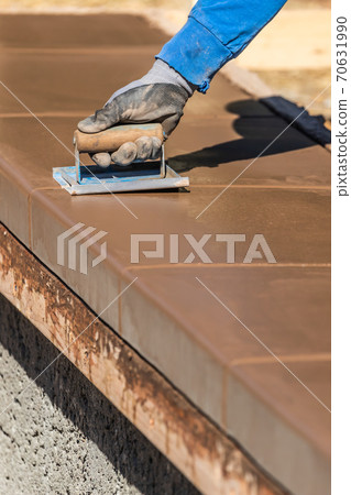 Construction Worker Using Hand Groover On Wet Cement Forming Coping Around New Pool Construction Worker Using Hand Groover On Wet Cement Forming Coping Around New Pool 70631990