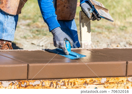 Construction Worker Using Trowel On Wet Cement Forming Coping Around New Pool Construction Worker Using Trowel On Wet Cement Forming Coping Around New Pool 70632016