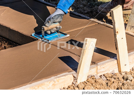 Construction Worker Using Hand Groover On Wet Cement Forming Coping Around New Pool Construction Worker Using Hand Groover On Wet Cement Forming Coping Around New Pool 70632026
