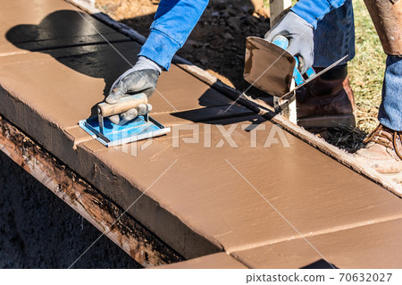 Construction Worker Using Hand Groover On Wet Cement Forming Coping Around New Pool Construction Worker Using Hand Groover On Wet Cement Forming Coping Around New Pool 70632027