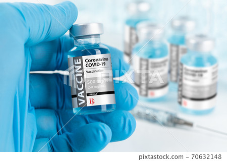Doctor or Nurse Wearing Surgical Glove Holding Coronavirus COVID-19 Vaccine Vial 70632148