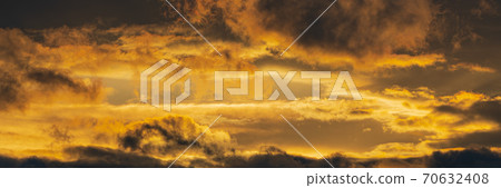 Panorama dramatic clouds illuminated rising of sun in sky to change weather. Natural meteorology background. Majestic cloudscape 70632408