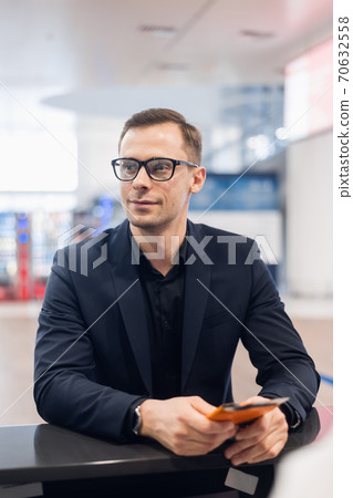 Handsome businessman handing over air ticket at airline check in counter 70632558