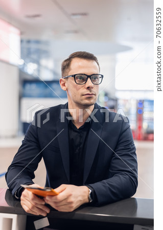 Midsection Of Male Passenger Showing Passport At Airport 70632559