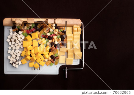Cheese dish with various cheeses and dried fruits on a sliced Board with devices for slicing.Special Board for slicing cheese with cheese and dried fruits Cheese dish with various cheeses and dried fruits on a sliced Board with devices for slicing.Special Board for slicing cheese with cheese and dried fruits 70632965