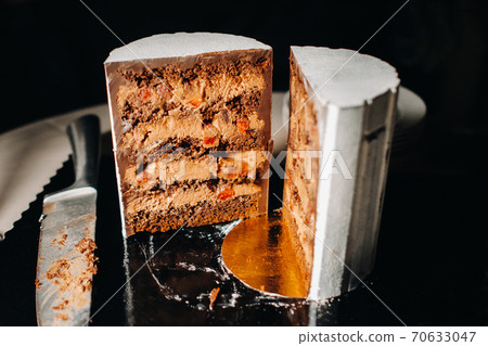 Amazing Cakes. Sliced chocolate wedding cake cake with amazing filling on a black background.Large cake in white chocolate Amazing Cakes. Sliced chocolate wedding cake cake with amazing filling on a black background.Large cake in white chocolate 70633047