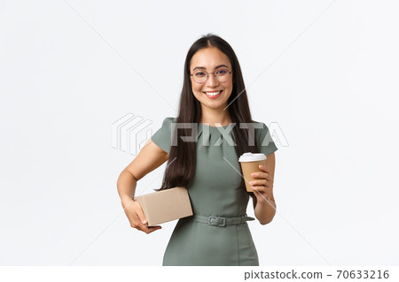 Smiling pretty asian female business owner, entrepreneur run own shop, holding package box and coffee, drinking take-away on her way to delivery office, sending parcel for her store customer Smiling pretty asian female business owner, entrepreneur run own shop, holding package box and coffee, drinking take-away on her way to delivery office, sending parcel for her store customer 70633216
