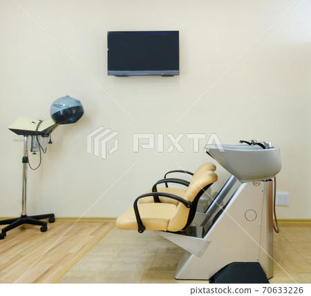 Chair for washing hair in a Barber shop. Interior of a Barber shop. A cruel place. Chair in beige leather in a beauty salon. 70633226