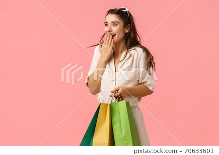 Excited and fascinated cute feminine brunette female in dress, holding shopping bags, wonder around mall, gasping excited cover mouth seeing something wonderful, pink background Excited and fascinated cute feminine brunette female in dress, holding shopping bags, wonder around mall, gasping excited cover mouth seeing something wonderful, pink background 70633601