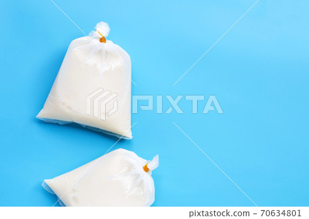 Soymilk in plastic bags on blue background. Soymilk in plastic bags on blue background. 70634801