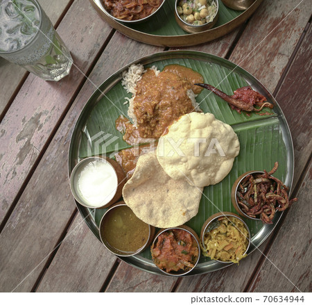 South Indian cuisine served on banana leaf. Top view. South Indian cuisine served on banana leaf. Top view. 70634944