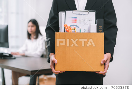 Businessman packaging and holding brown cardboard box because fired from work. Businessman packaging and holding brown cardboard box because fired from work. 70635878