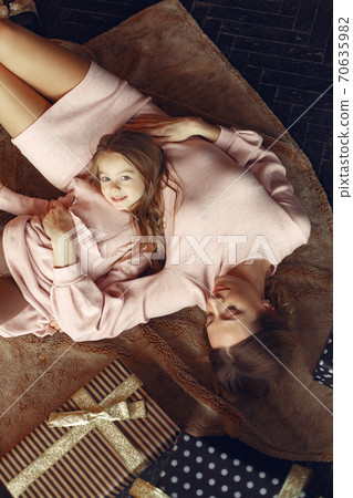 Mother with cute daughter at home near fireplace Mother with cute daughter at home near fireplace 70635982