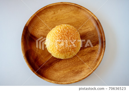 Melon bread on a wooden plate seen from above 70636523