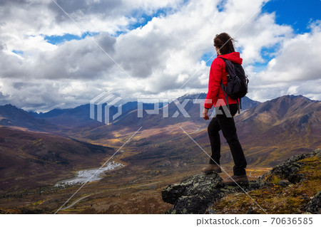 Woman Standing and Looking at Mountain Range on a Cloudy Fall Day 70636585
