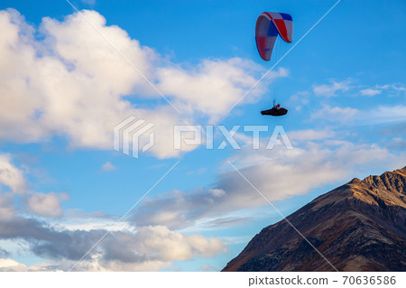 Paraglider flying over Scenic Mountain Range in Canadian Nature 70636586