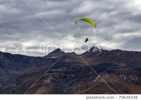 Paraglider flying over Scenic Mountain Range in Canadian Nature 70636598