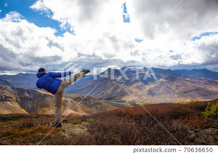 Man Kicking and Practicing Martial Arts on top of a Mountain Man Kicking and Practicing Martial Arts on top of a Mountain 70636650