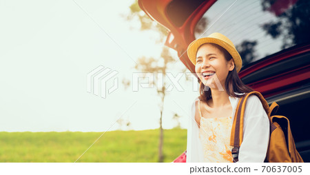 Happy young Asian woman wearing a hat and smiling with sitting on a back car, travel in the summer Happy young Asian woman wearing a hat and smiling with sitting on a back car, travel in the summer 70637005