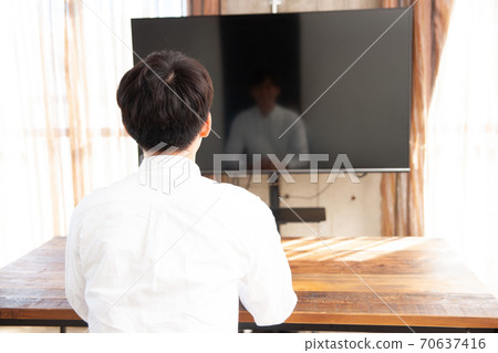 A man spending time watching TV in the room A man spending time watching TV in the room 70637416