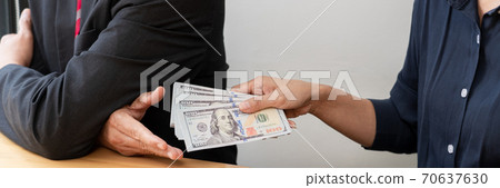 Businessman reciving money United States Dollars bills to corruption from his partner in business at working desk - bribery concept. 70637630