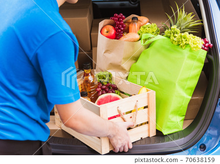 Delivery man grocery prepare fresh vegetables food in wooden basket on back car 70638159